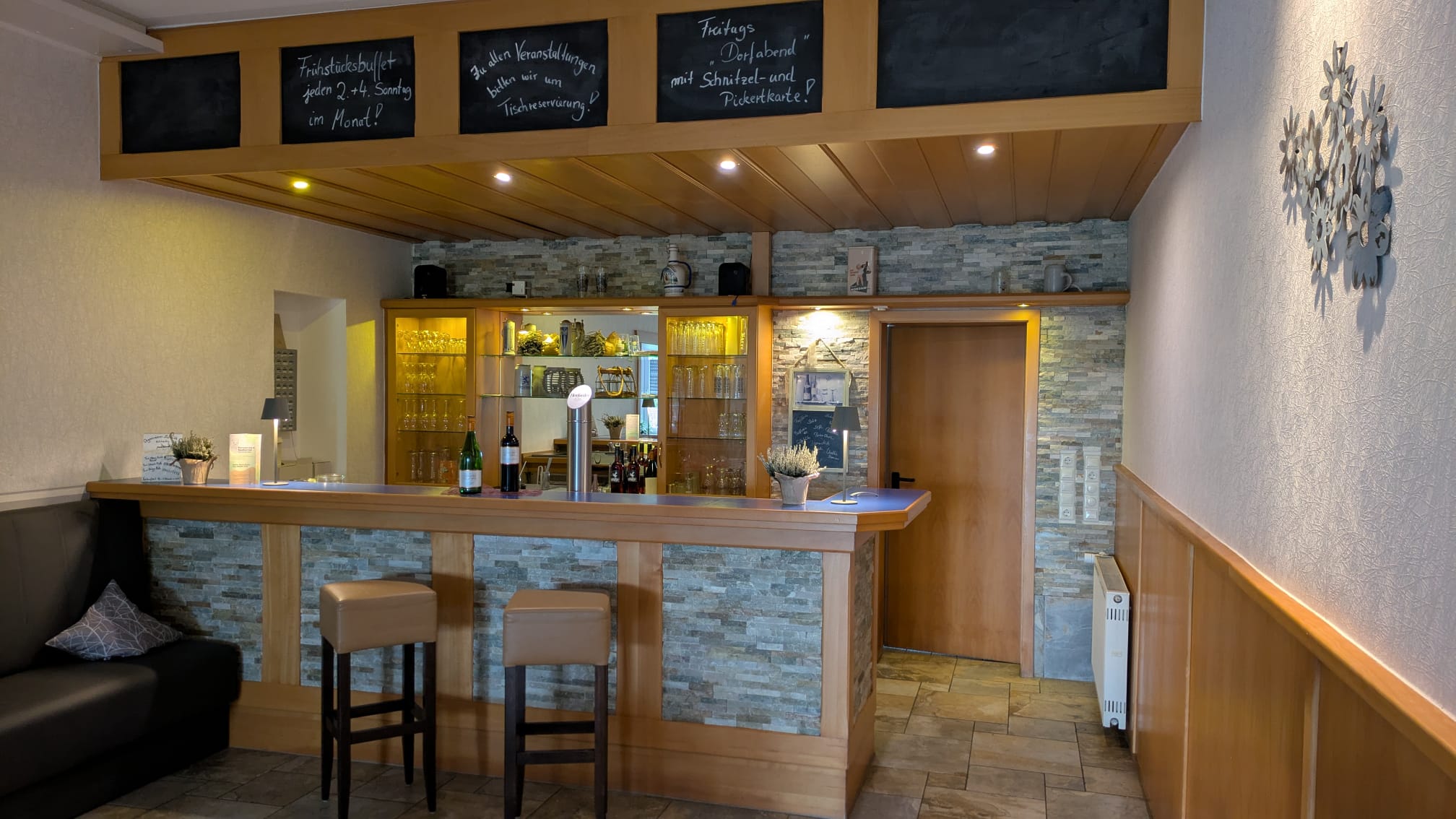 Großer Saal – Theke mit Holzverkleidung und Natursteinwand