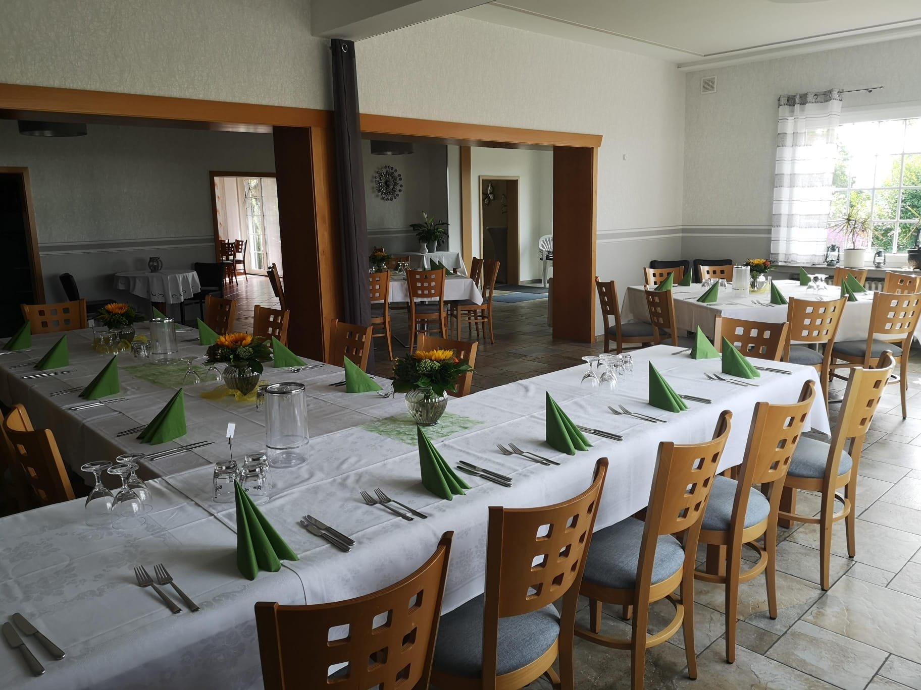 Großer Saal – Übersicht mit langen Tafeln und Sonnenblumen